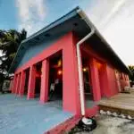 Coral-pink Beachside Villa with blue trim at Mars Bay Bonefish Lodge overlooking the Caribbean Sea.