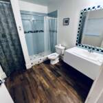 South Villa guest bathroom at Mars Bay Bonefish Lodge with tiled walk-in shower.